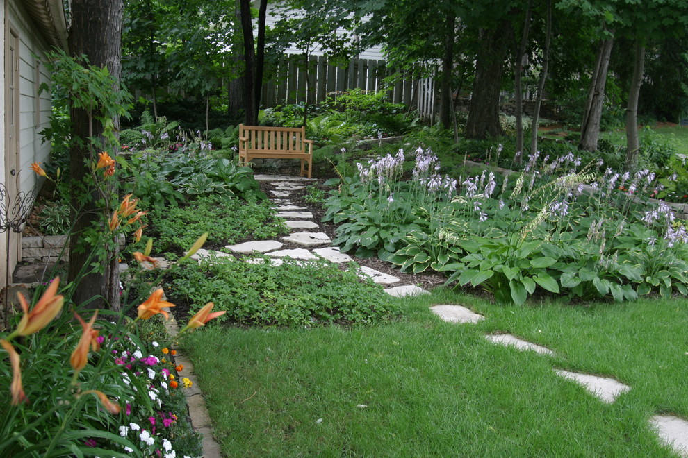 Diseño de camino de jardín tradicional de tamaño medio en patio trasero con exposición reducida al sol, adoquines de piedra natural y jardín francés