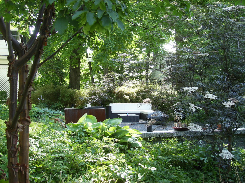 Foto di un piccolo giardino xeriscape contemporaneo in ombra dietro casa in primavera con un focolare e ghiaia