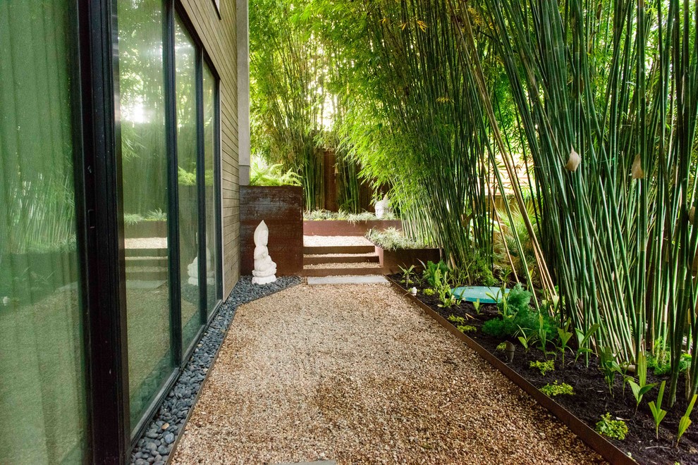 Cette image montre un jardin à la française arrière asiatique de taille moyenne et au printemps avec du gravier, une exposition ombragée et des solutions pour vis-à-vis.
