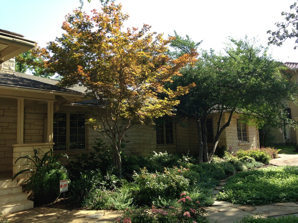 Design ideas for a mid-sized rustic partial sun front yard stone landscaping in Dallas.