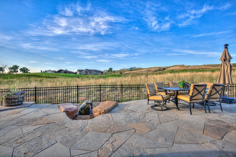 Photo of a large southwestern drought-tolerant, desert and partial sun backyard stone landscaping in Denver.