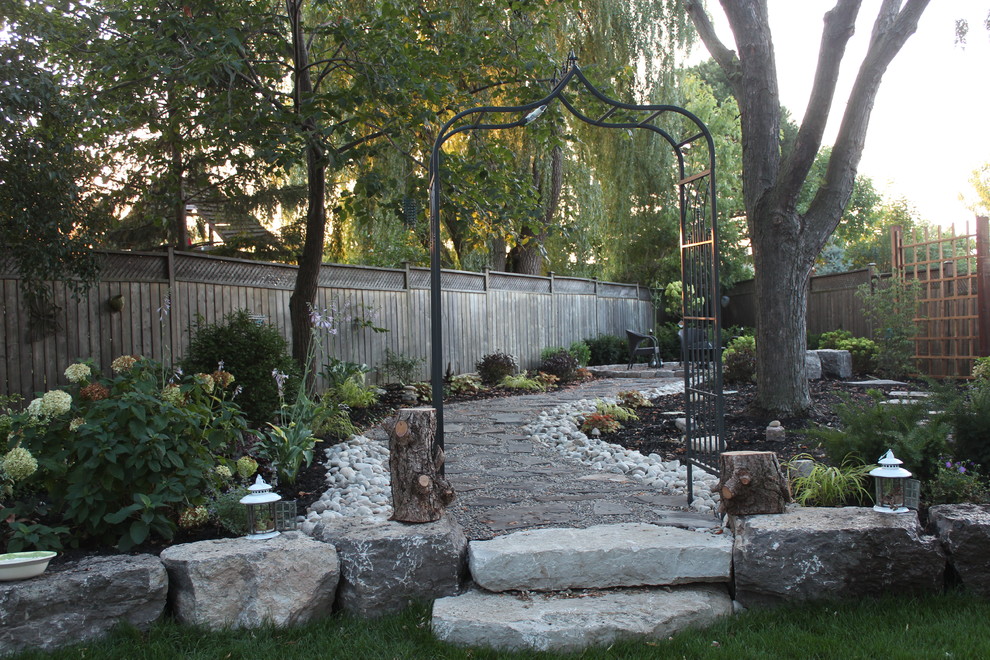 Design ideas for a large traditional back fully shaded garden in Toronto with a garden path and natural stone paving.