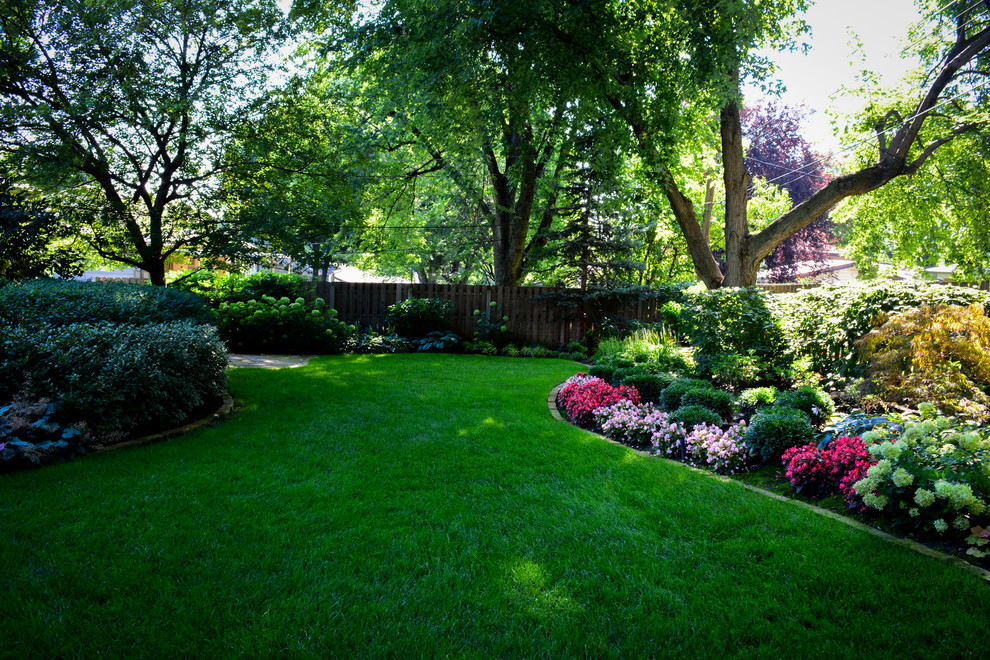 Foto de jardín clásico de tamaño medio en patio trasero con exposición reducida al sol y adoquines de piedra natural