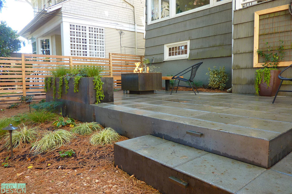 シアトルにある小さなコンテンポラリースタイルのおしゃれな庭 (ファイヤーピット、日陰、コンクリート敷き	) の写真