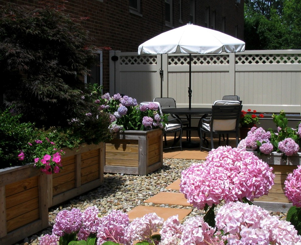 This is an example of a medium sized traditional roof full sun garden for summer in Cleveland with a potted garden.
