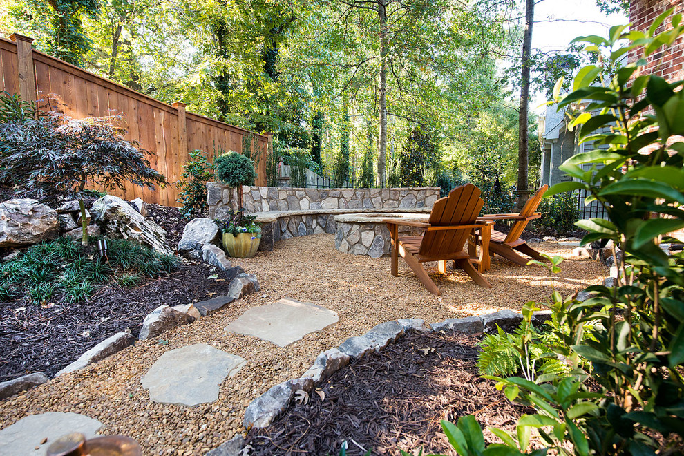 Large rustic back partial sun garden for summer in Atlanta with a fire feature and natural stone paving.