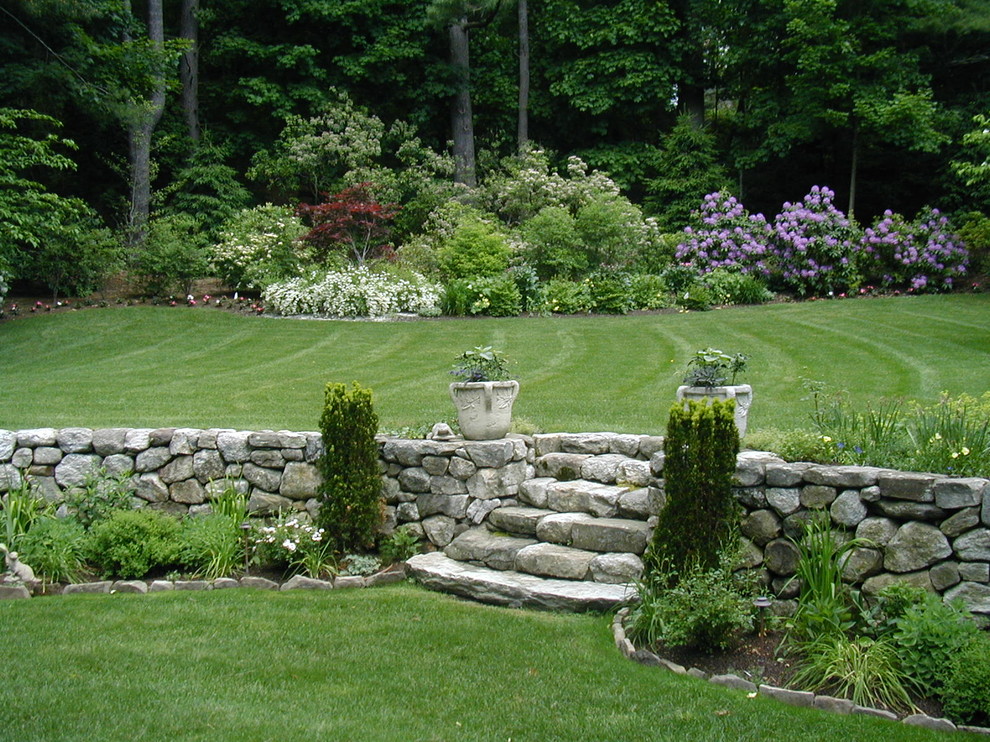 На фото: огромный участок и сад на заднем дворе в викторианском стиле с газонным бордюром