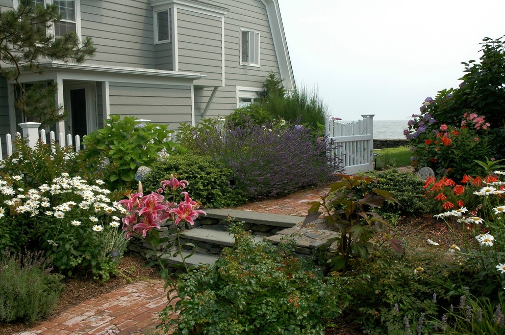 Esempio di un piccolo giardino formale costiero esposto in pieno sole davanti casa in estate con un ingresso o sentiero e pavimentazioni in mattoni