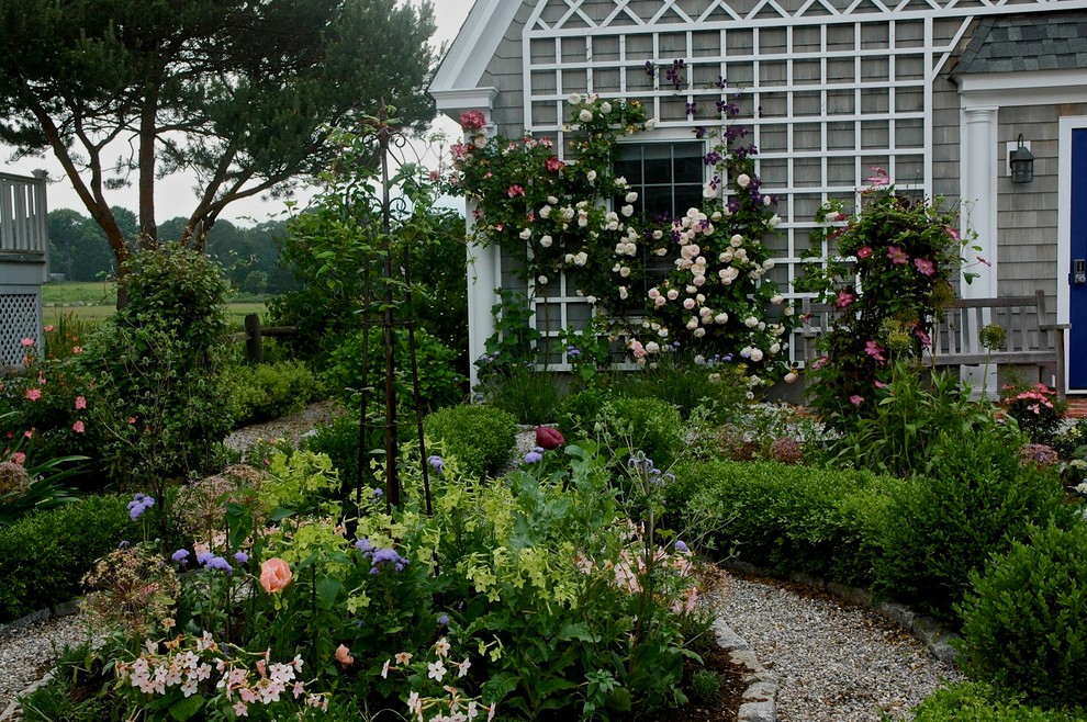 Idéer för en mellanstor klassisk formell trädgård framför huset, med en trädgårdsgång och grus