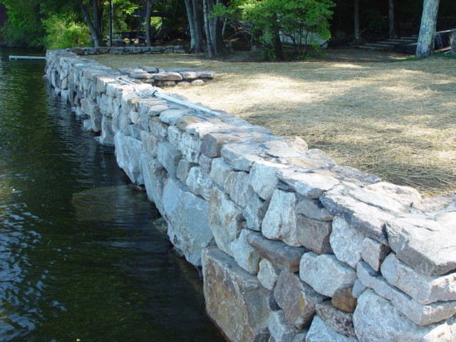 This is an example of a mid-sized eclectic partial sun hillside stone retaining wall landscape in Boston for summer.
