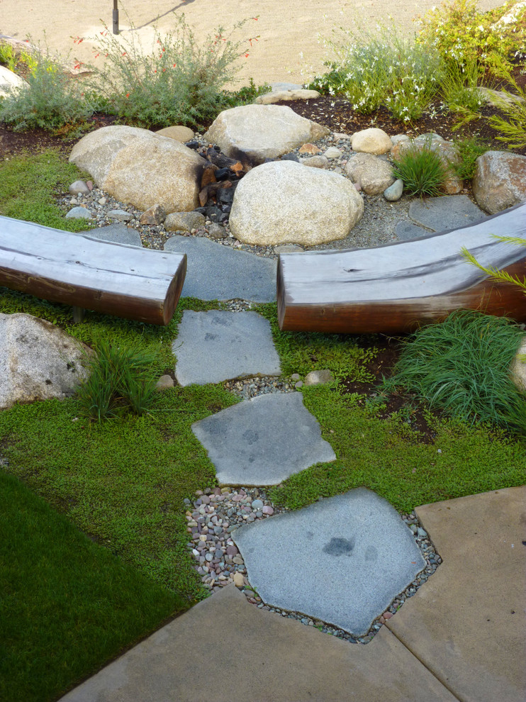 Inspiration for a medium sized nautical back partial sun garden in Seattle with natural stone paving and a retaining wall.
