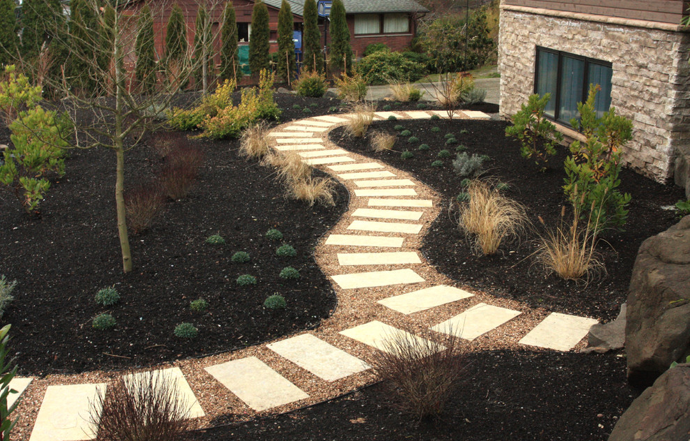 This is an example of a large retro front xeriscape full sun garden in Seattle with natural stone paving and a garden path.