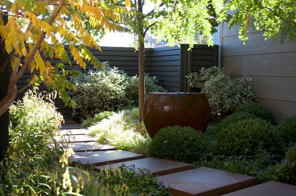 Immagine di un piccolo giardino minimalista esposto a mezz'ombra dietro casa con un ingresso o sentiero e pavimentazioni in cemento