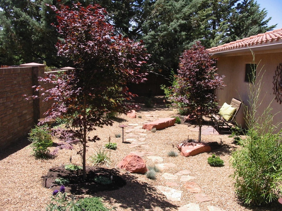 Immagine di un giardino etnico davanti casa con fontane e pavimentazioni in cemento