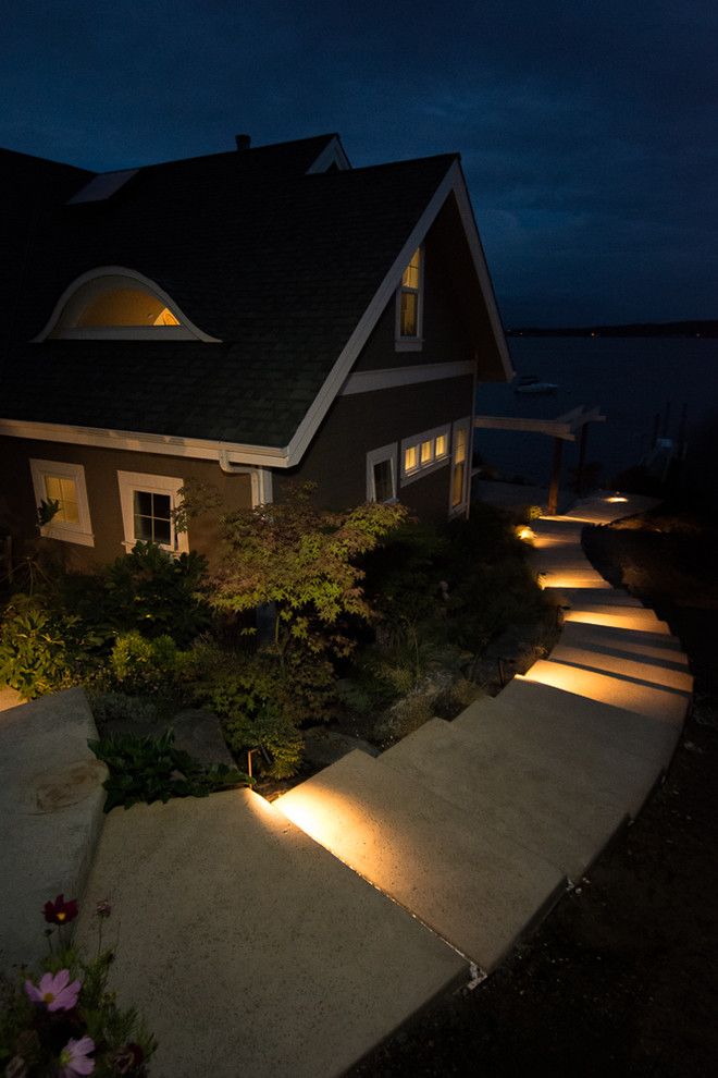 Inspiration for a beach style sloped full sun garden in Seattle with a retaining wall and natural stone paving.