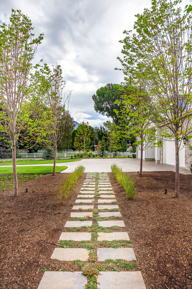 ソルトレイクシティにあるラグジュアリーな広いトラディショナルスタイルのおしゃれな庭 (庭への小道、日向、コンクリート敷き	) の写真