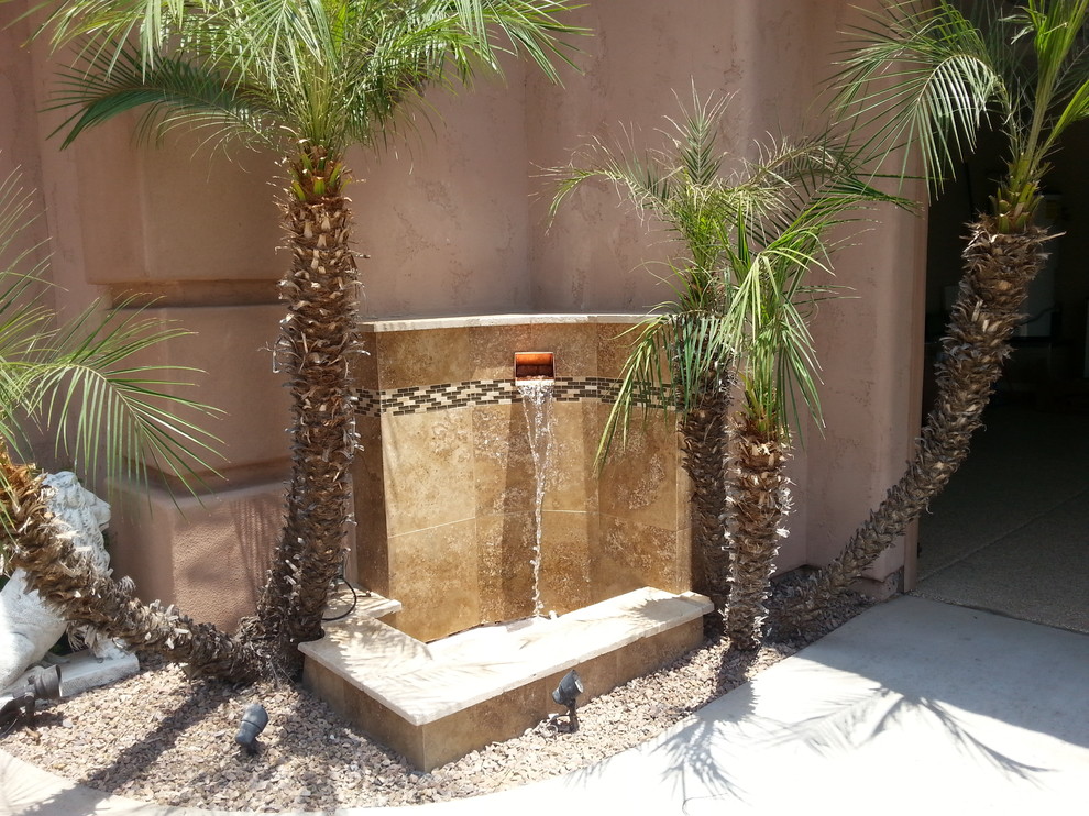 Photo of a small contemporary courtyard driveway full sun garden in Phoenix with a water feature.