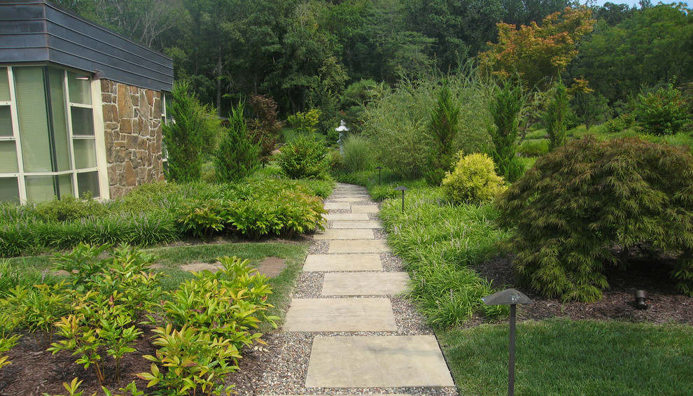 Immagine di un ampio giardino etnico esposto in pieno sole dietro casa in estate con pavimentazioni in pietra naturale