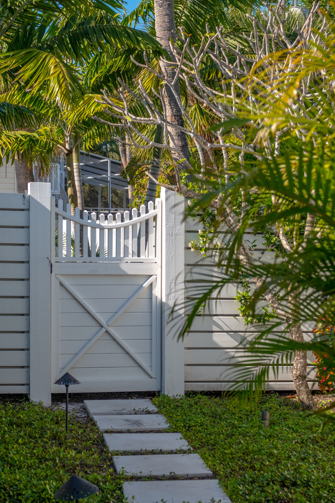 Foto di un giardino xeriscape stile marino esposto a mezz'ombra di medie dimensioni e nel cortile laterale in estate con un ingresso o sentiero, pavimentazioni in cemento e recinzione in legno
