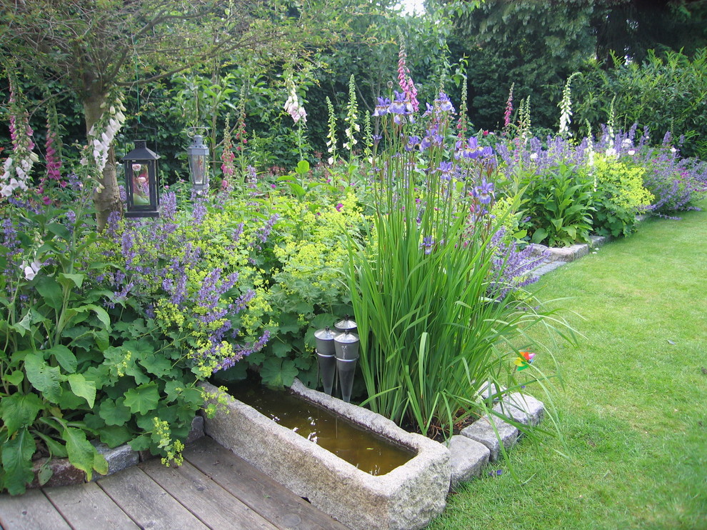 Foto de jardín escandinavo de tamaño medio en verano en patio delantero con jardín francés, jardín vertical, exposición parcial al sol y adoquines de hormigón
