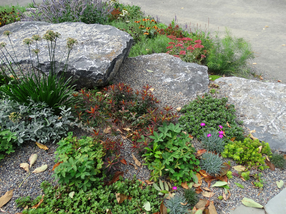 This is an example of a small rustic full sun front yard stone landscaping in New York for summer.