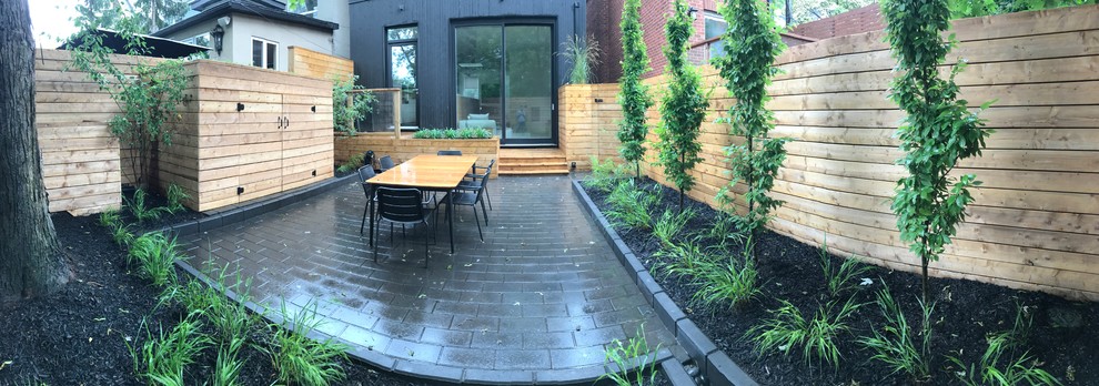 Cette image montre un petit aménagement d'entrée ou allée de jardin arrière minimaliste l'été avec une exposition partiellement ombragée et des pavés en brique.