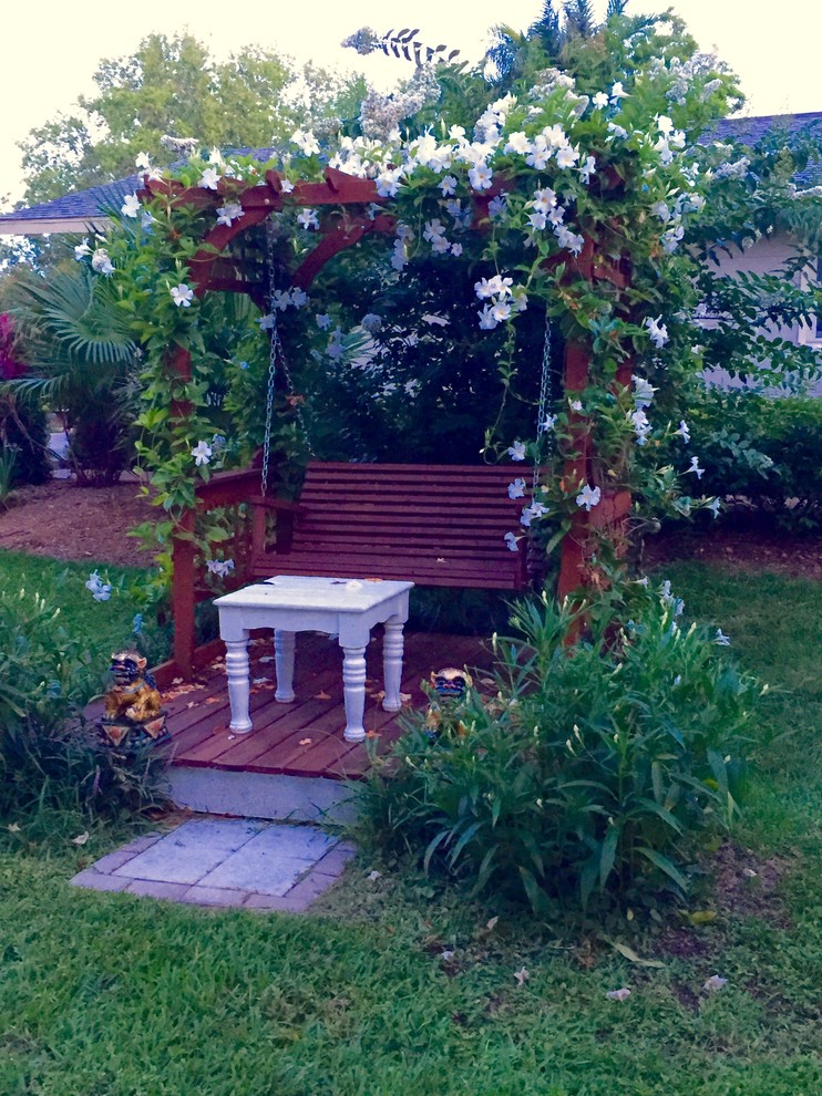 Ejemplo de jardín de secano tropical pequeño en patio lateral con fuente, exposición parcial al sol y gravilla