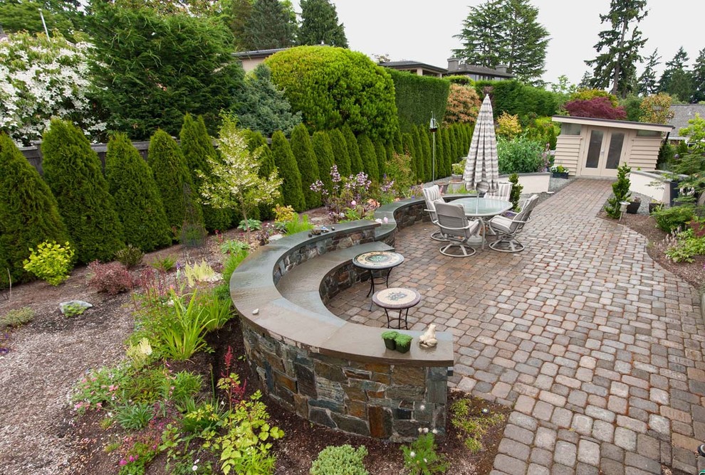 На фото: большой регулярный сад на заднем дворе в классическом стиле с покрытием из каменной брусчатки с