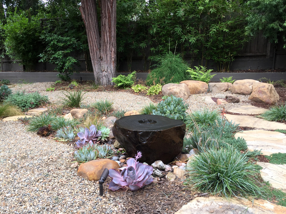 Imagen de jardín de secano rústico pequeño en patio trasero con fuente, exposición parcial al sol y adoquines de piedra natural
