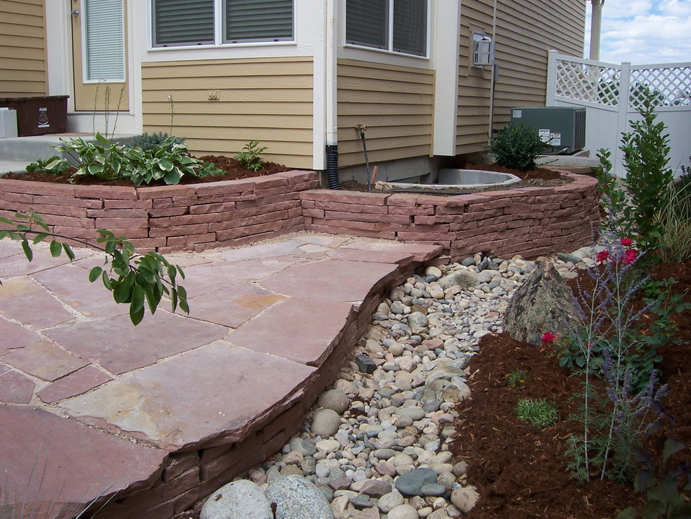 Design ideas for a small traditional drought-tolerant backyard river rock landscaping in Denver.