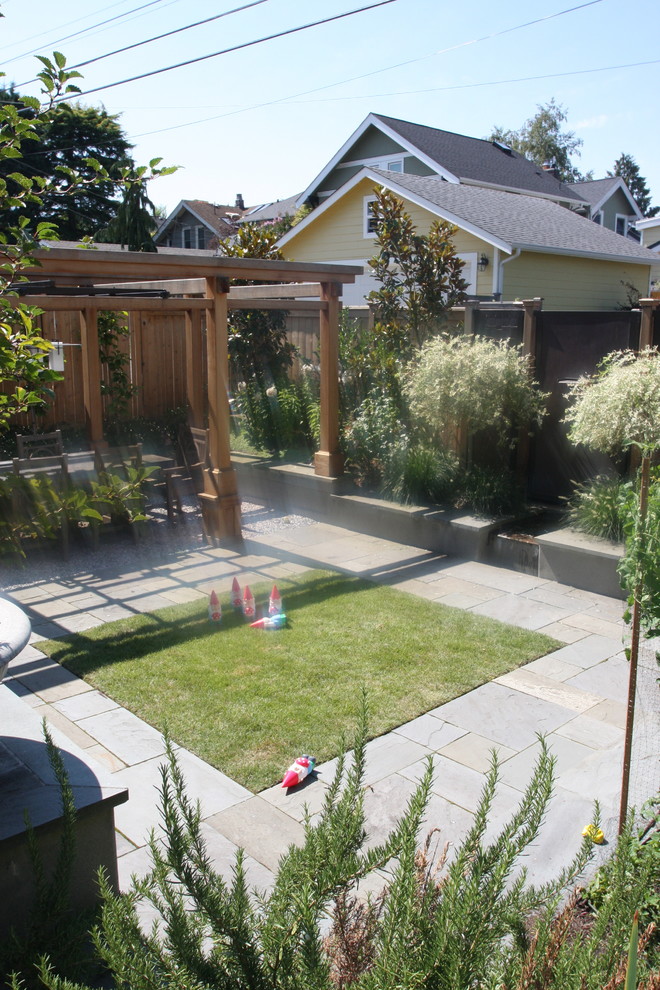 Inspiration for a mid-sized craftsman full sun backyard stone retaining wall landscape in Seattle.