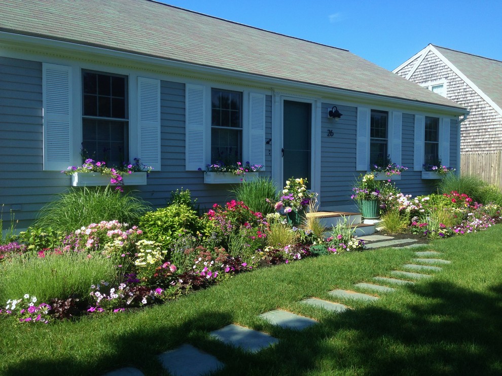 Exempel på en liten klassisk trädgård i delvis sol framför huset på våren, med en trädgårdsgång och marksten i betong