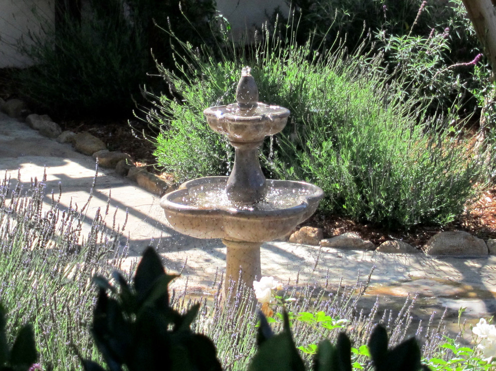 Diseño de camino de jardín de secano mediterráneo de tamaño medio en verano en patio delantero con exposición total al sol y adoquines de piedra natural
