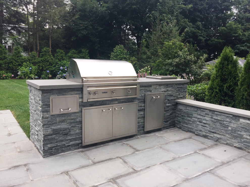 Photo of a small contemporary backyard stone landscaping in New York with a fire pit for summer.