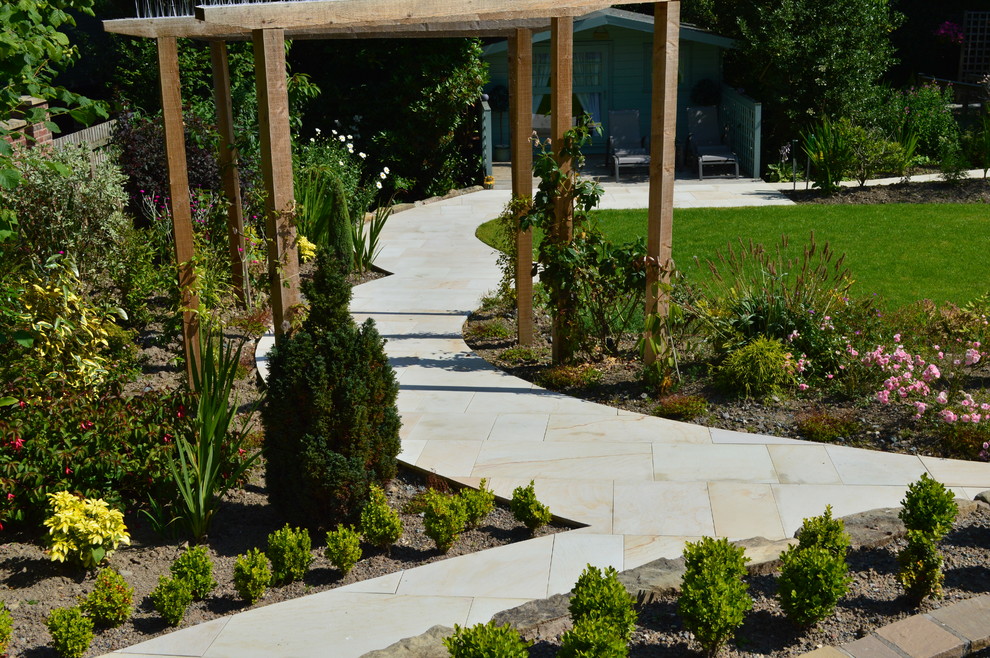 Идея дизайна: большой солнечный участок и сад на заднем дворе в классическом стиле с садовой дорожкой или калиткой, хорошей освещенностью и покрытием из каменной брусчатки