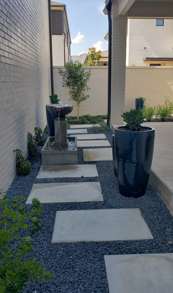 Immagine di un piccolo giardino xeriscape minimalista in ombra nel cortile laterale con fontane e pavimentazioni in cemento