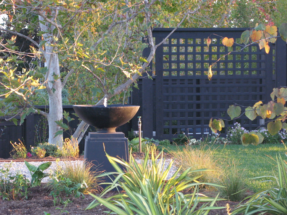 Пример оригинального дизайна: участок и сад в стиле фьюжн с забором