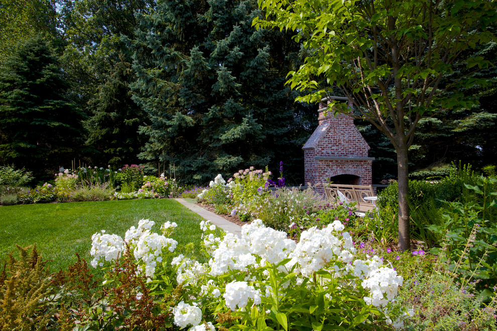 Idee per un grande giardino formale country esposto a mezz'ombra nel cortile laterale con un focolare e pavimentazioni in pietra naturale