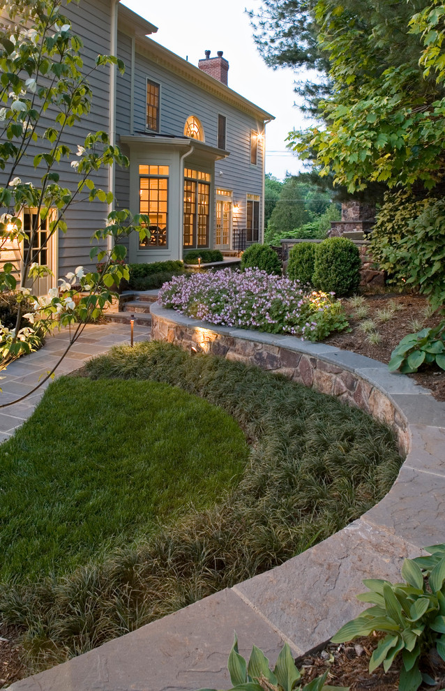 Cette image montre un grand jardin arrière traditionnel avec un foyer extérieur et des pavés en pierre naturelle.