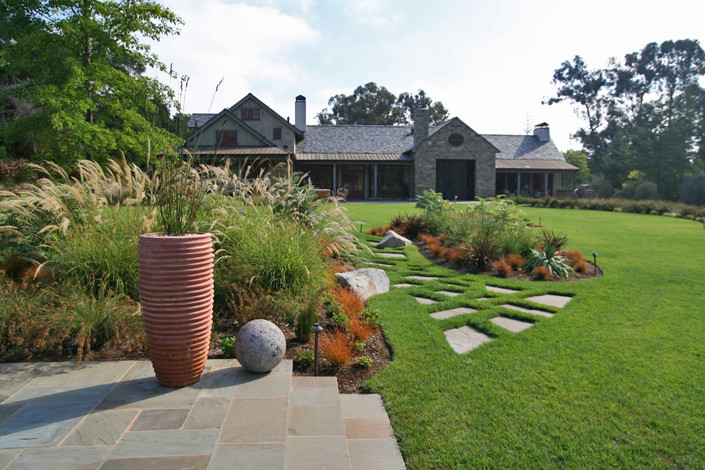 Esempio di un ampio giardino mediterraneo davanti casa con pavimentazioni in pietra naturale e un giardino in vaso