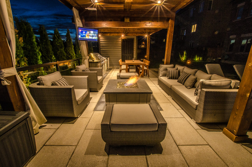 Photo of a large contemporary back patio in Toronto with a water feature and natural stone paving.