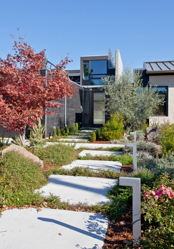 Пример оригинального дизайна: участок и сад на переднем дворе в стиле модернизм с мощением тротуарной плиткой