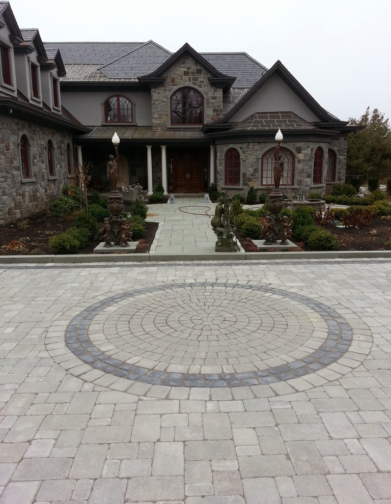 Photo of a large transitional front yard concrete paver landscaping in Burlington.