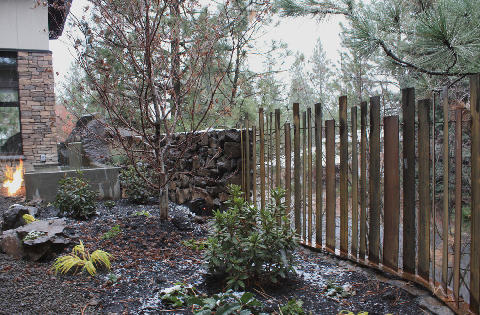 This is an example of a small contemporary partial sun courtyard gravel retaining wall landscape in Seattle.