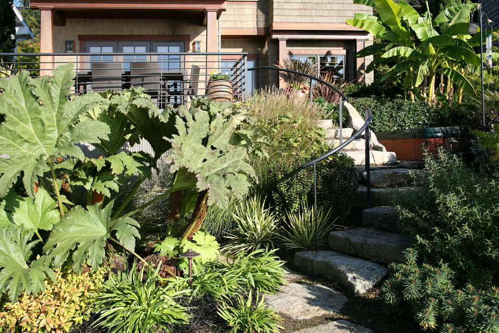 Exemple d'un jardin arrière craftsman de taille moyenne avec une exposition ensoleillée et des pavés en pierre naturelle.