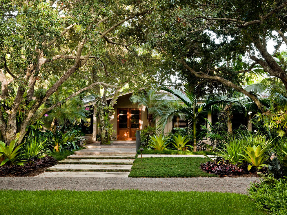 Foto på en tropisk trädgård framför huset