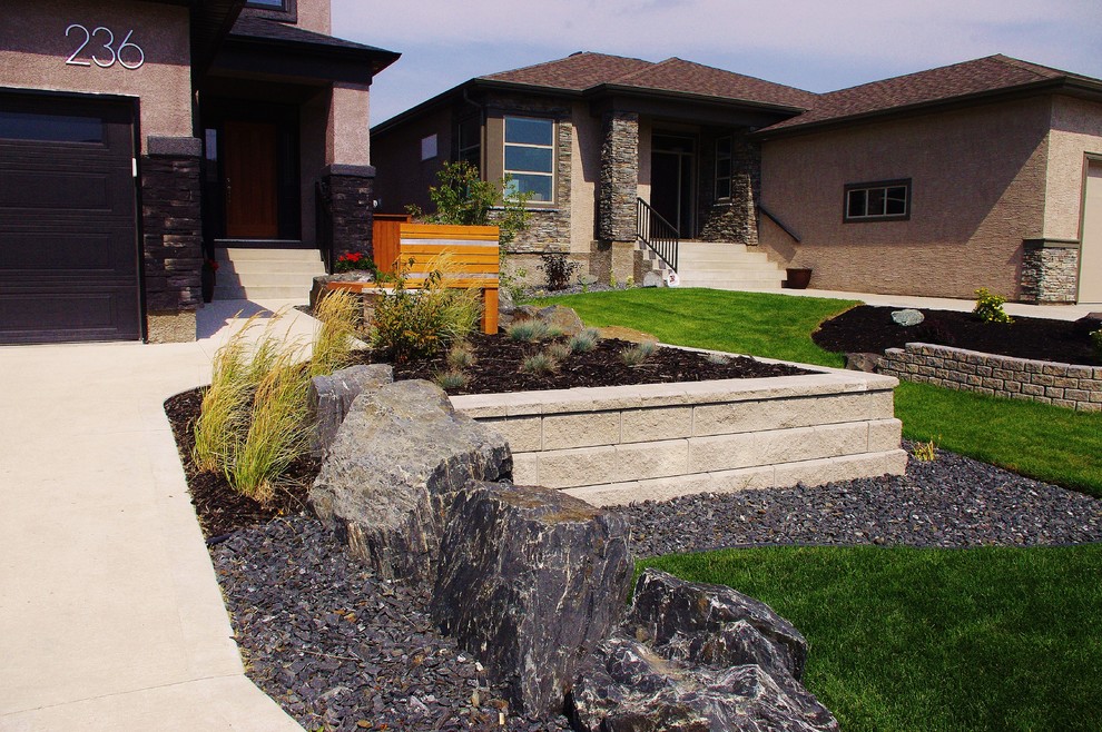 Idee per un giardino minimalista esposto in pieno sole di medie dimensioni e davanti casa con un muro di contenimento e graniglia di granito