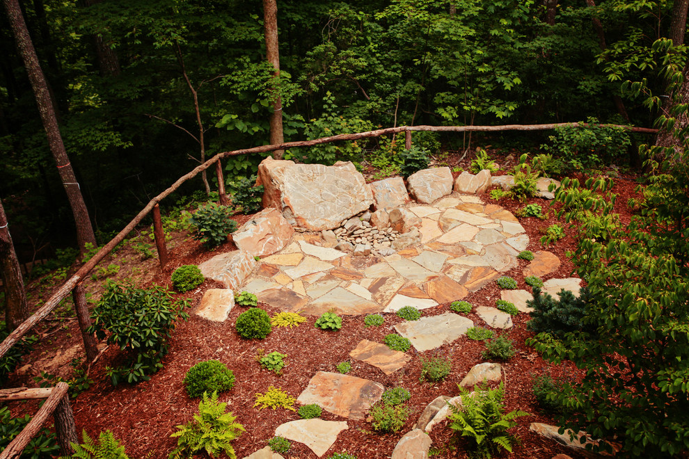 Design ideas for a mid-sized rustic partial sun backyard stone landscaping in Charlotte with a fire pit for spring.