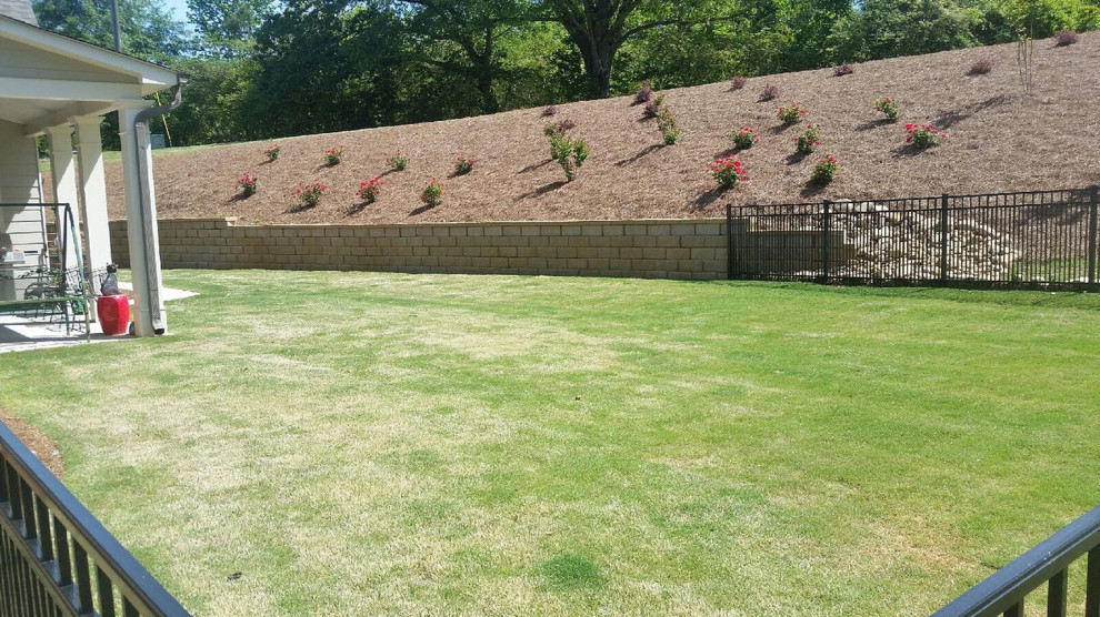 Idée de décoration pour un grand jardin à la française arrière tradition l'été avec une exposition partiellement ombragée, un paillis et un mur de soutènement.
