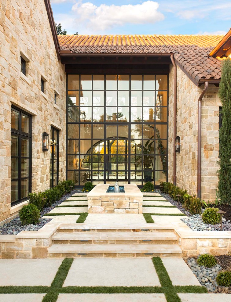 Photo of a mediterranean full sun garden in Dallas with a water feature.
